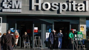 Varias personas con la mascarilla, salen del Hospital de La Paz de Madrid