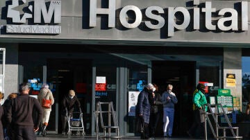 Varias personas con la mascarilla, salen del Hospital de La Paz de Madrid