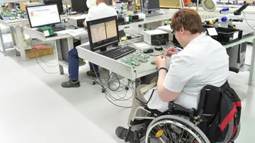 Trabajador informático en silla de ruedas Trabajador informático en silla de ruedas