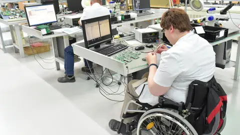 Trabajador informático en silla de ruedas Trabajador informático en silla de ruedas