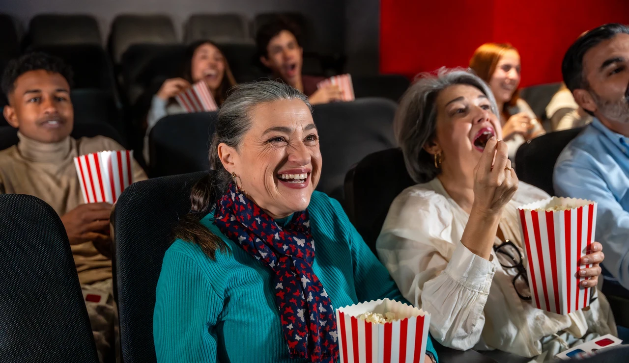 Mujer mayor disfrutando de una película en el cine