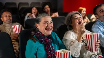 Mujer mayor disfrutando de una película en el cine Mujer mayor disfrutando de una película en el cine