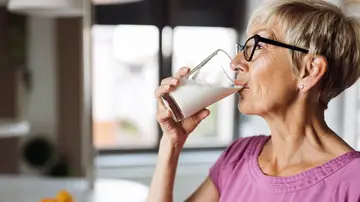 Mujer mayor bebiendo un vaso de leche Mujer mayor bebiendo un vaso de leche