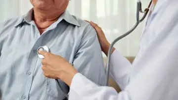 Médica auscultando a un hombre Médica auscultando a un hombre