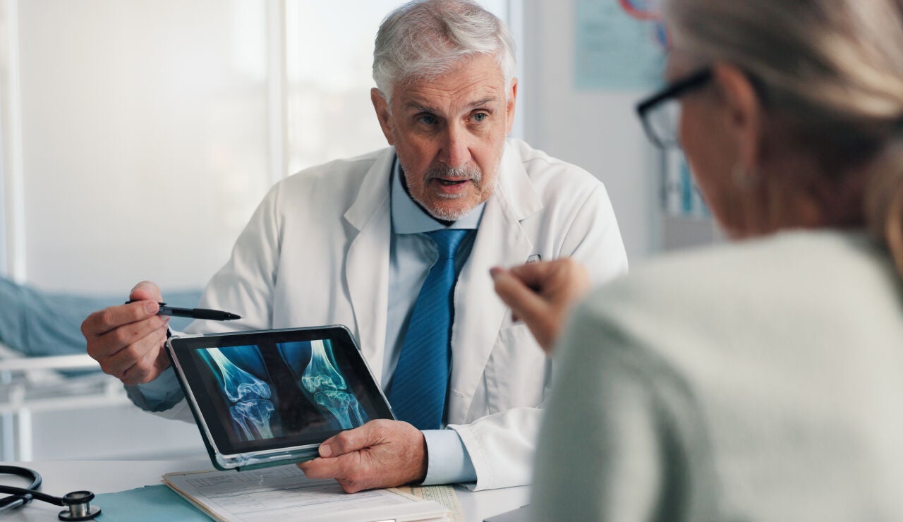 M&eacute;dico experto hablando con paciente de sus huesos