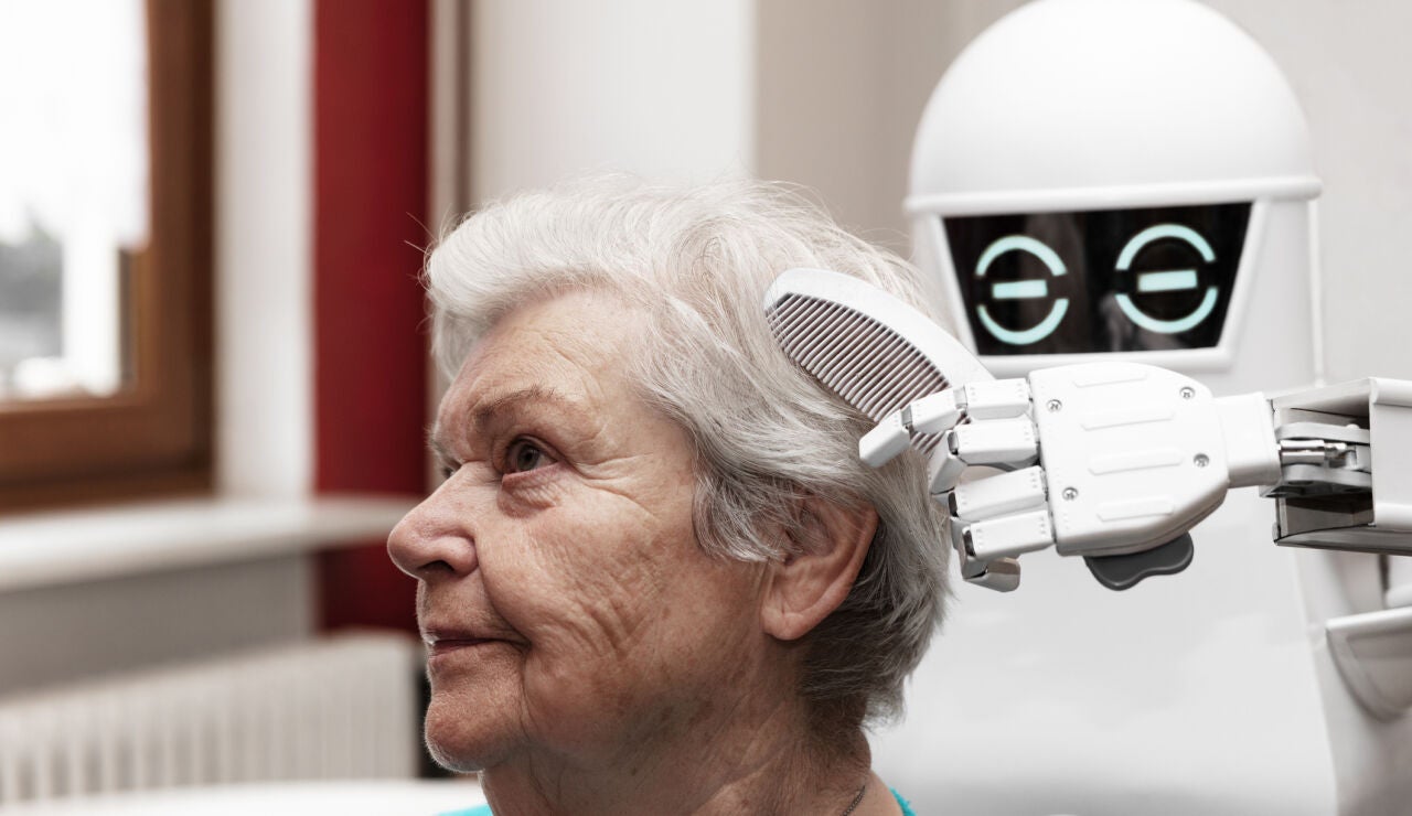 Un cuidador rob&oacute;tico est&aacute; peinando el cabello de una adulta de edad avanzada