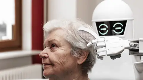 Un cuidador robótico está peinando el cabello de una adulta de edad avanzada Un cuidador robótico está peinando el cabello de una adulta de edad avanzada