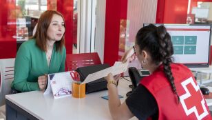 Personal de Cruz Roja asesora a una mujer en materia de empleo.