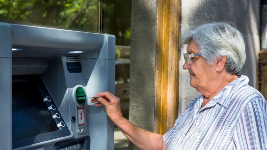 Mujer mayor sacando dinero del cajero
