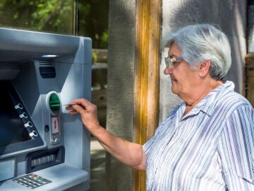 Mujer mayor sacando dinero del cajero