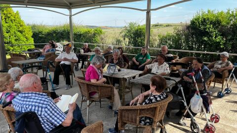 Grupo de personas en una terraza leyendo y compartiendo un rato juntos