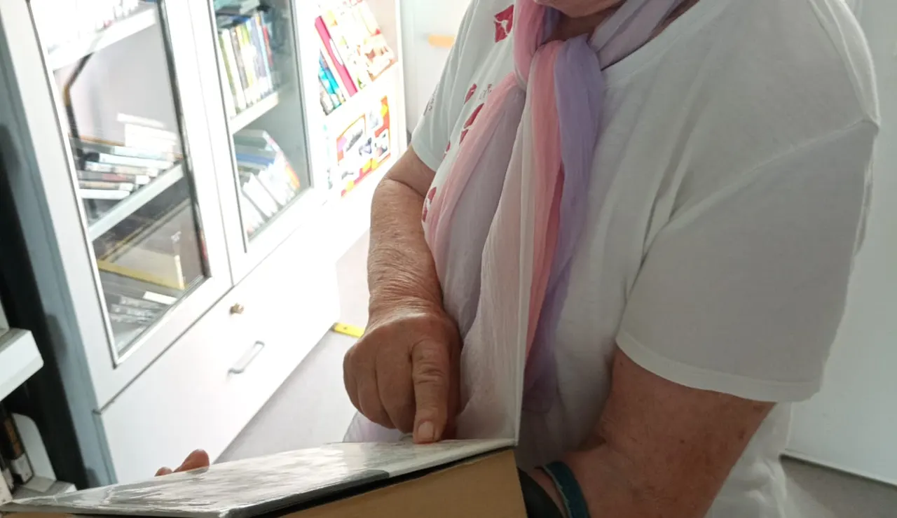 Mujer sujetando un libro mientras lee su sinopsis.