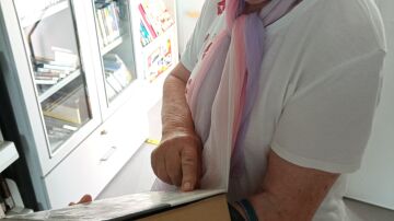 Mujer sujetando un libro mientras lee su sinopsis.