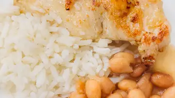 Primer plano de un delicioso pollo a la parrilla servido con arroz y frijoles en un plato. Primer plano de un delicioso pollo a la parrilla servido con arroz y frijoles en un plato.