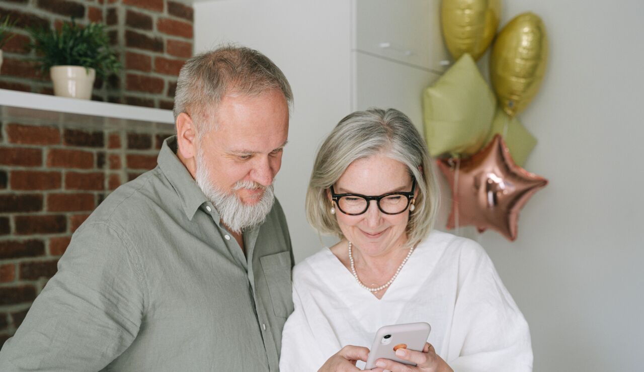 Pareja de ancianos consulstando el m&oacute;vil