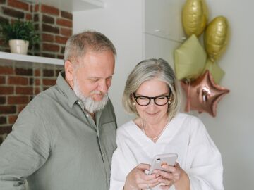 Pareja de ancianos consulstando el m&oacute;vil