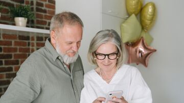 Pareja de ancianos consulstando el m&oacute;vil