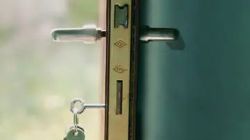 Una vista en primer plano de una cerradura de puerta con llaves insertadas, iluminada por la luz natural Una vista en primer plano de una cerradura de puerta con llaves insertadas, iluminada por la luz natural