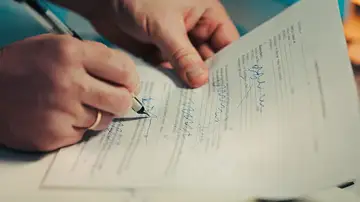 Primer plano de manos firmando un contrato comercial en una oficina. Ideal para temas legales y financieros. Primer plano de manos firmando un contrato comercial en una oficina. Ideal para temas legales y financieros.
