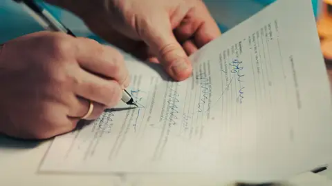 Primer plano de manos firmando un contrato comercial en una oficina. Ideal para temas legales y financieros. Primer plano de manos firmando un contrato comercial en una oficina. Ideal para temas legales y financieros.