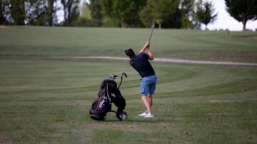 Persona de espaldas jugando al golf