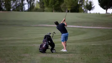 Persona de espaldas jugando al golf Persona de espaldas jugando al golf